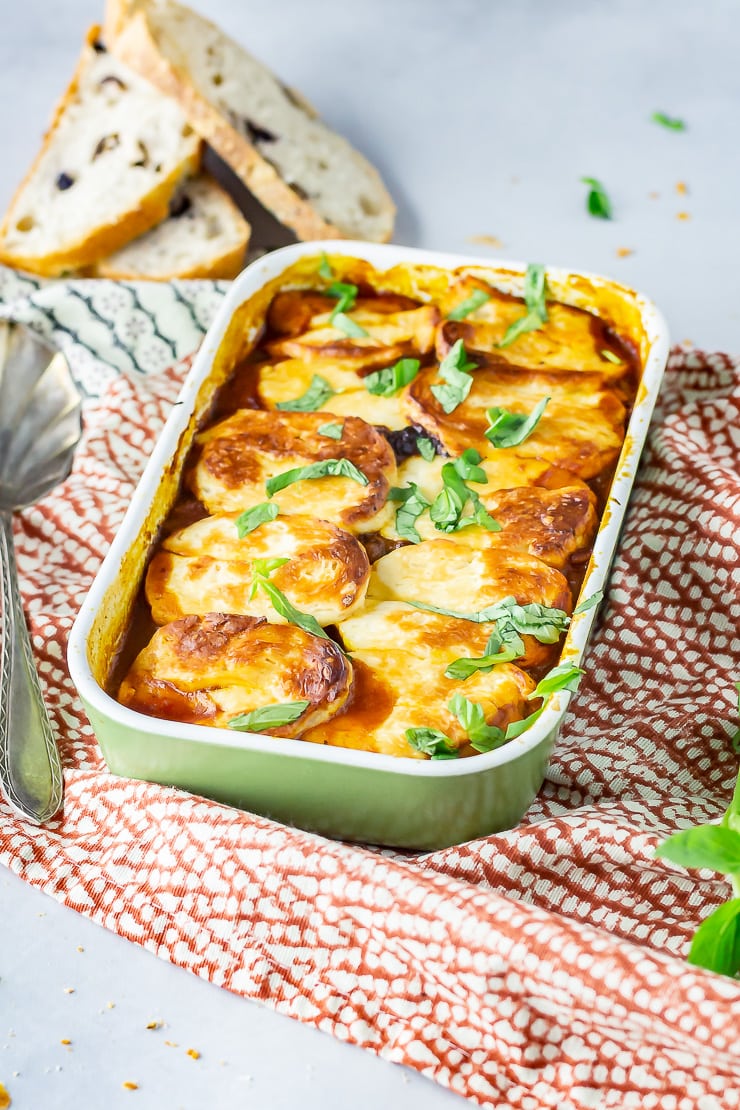 Side angle shot of halloumi bake in a green baking dish