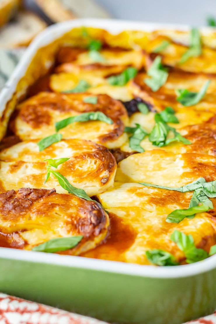 Close up side angle shot of halloumi bake in a green baking dish