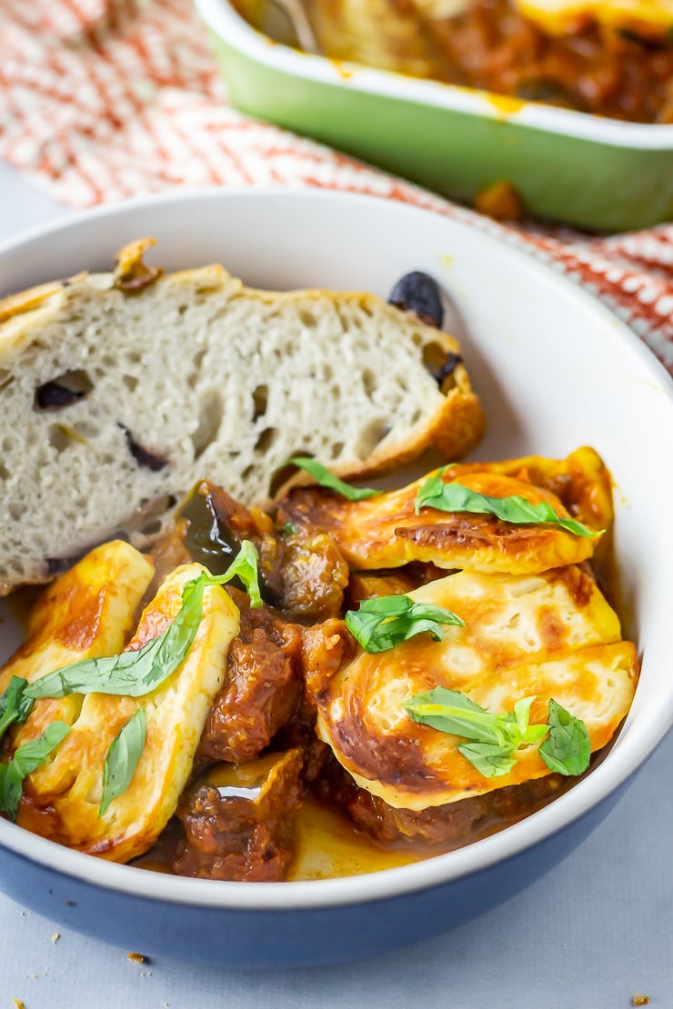 Blue bowl of a portion of halloumi bake with bread