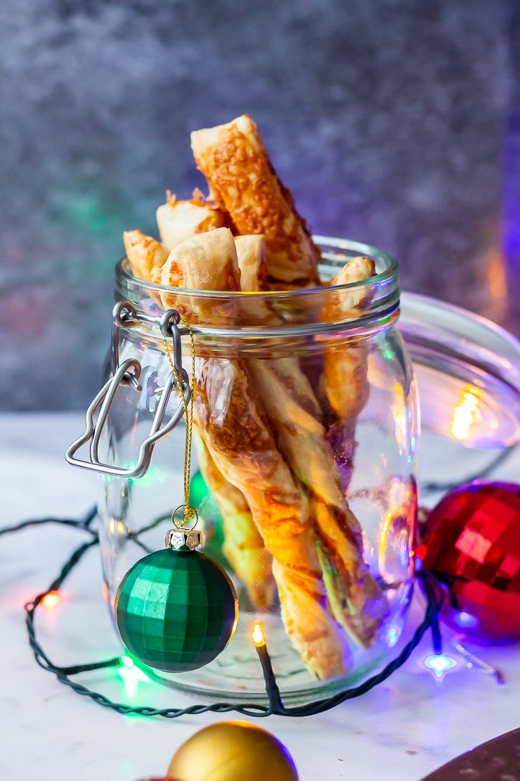 Side angle shot of chipotle cheese twist in a glass jar with Christmas decorations