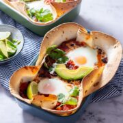 Side angle shot of huevos rancheros baked eggs on a marble background