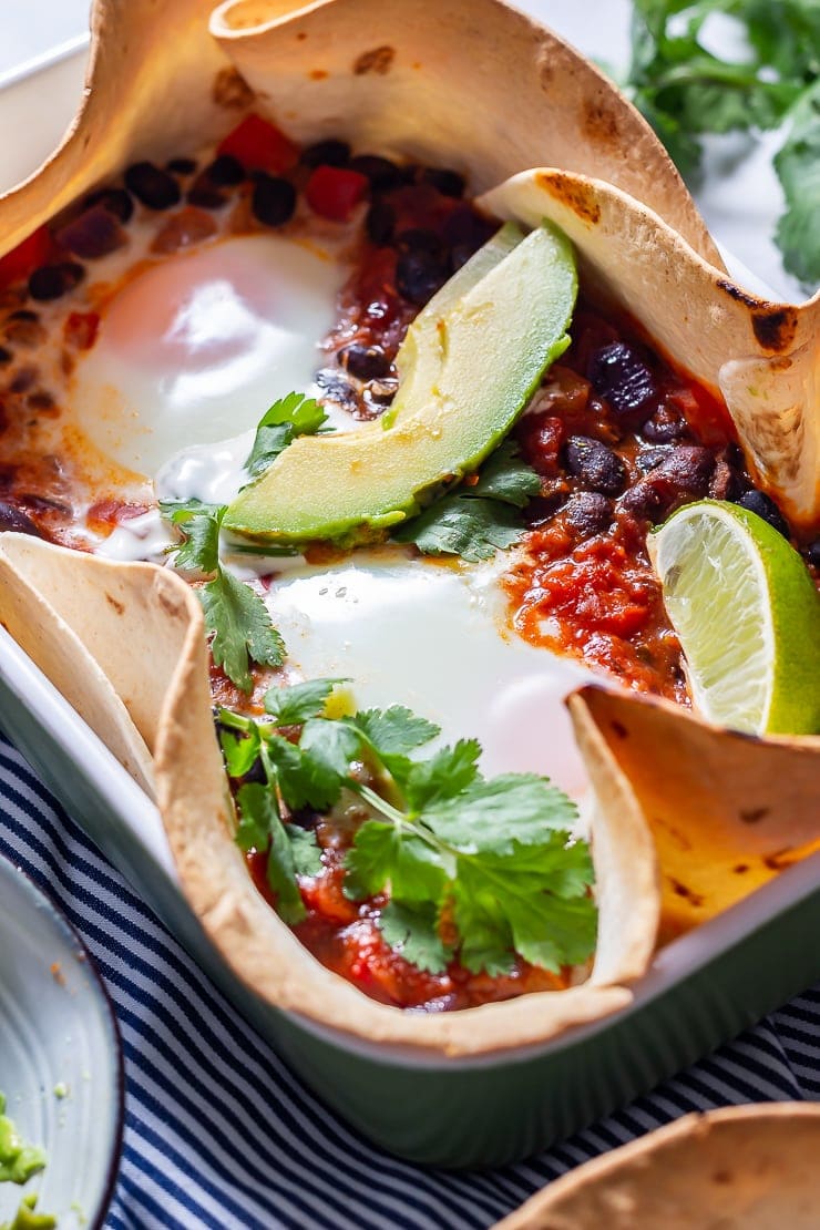 Close up of huevos rancheros baked eggs with avocado