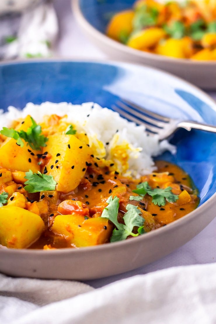 Side on shot of creamy prawn curry in a blue bowl 