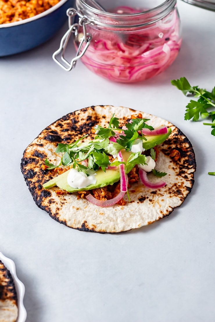 Side on shot of salmon tacos on a grey background 