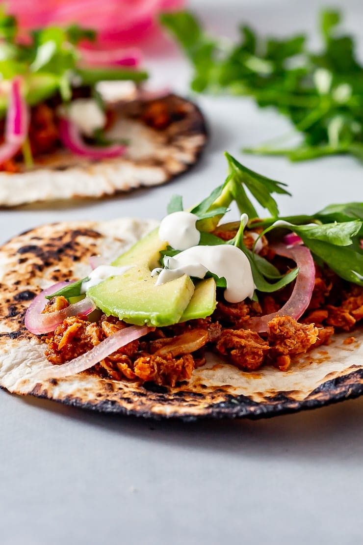 Side on shot of salmon tacos on a grey background