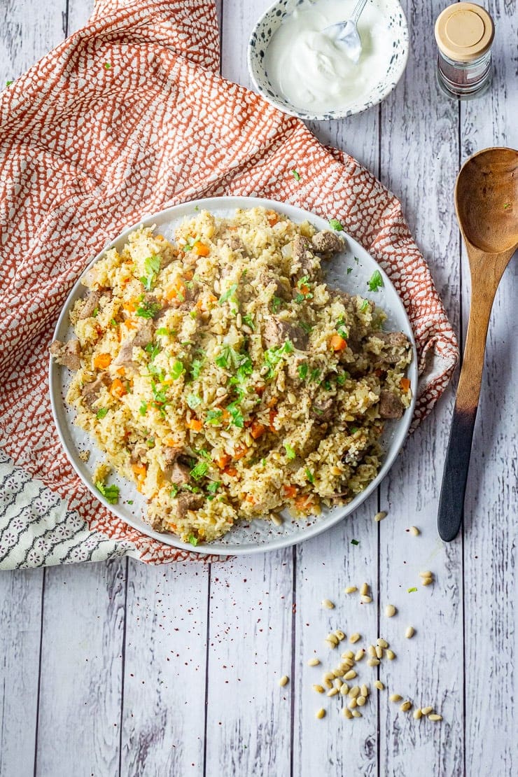 Overhead shot of leftover turkey pilaf on a platter on a white wooden backgound