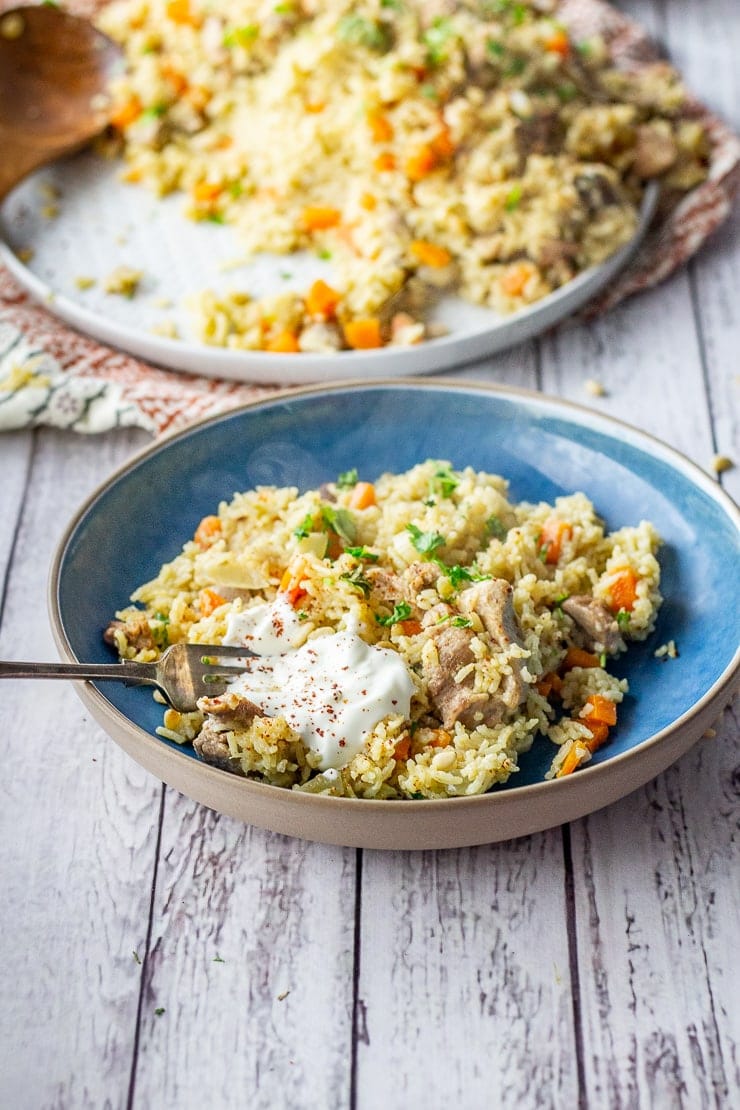 Leftover turkey pilaf in a blue bowl on a white wooden background