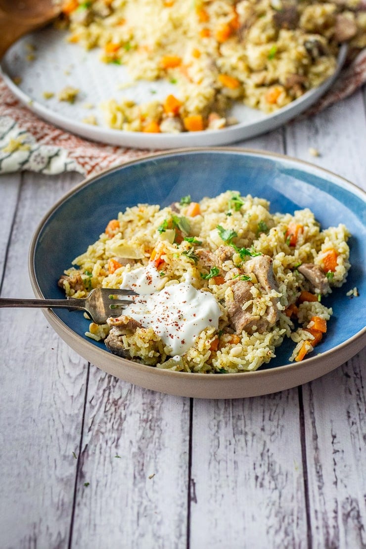 Leftover turkey pilaf in a blue bowl on a white wooden background