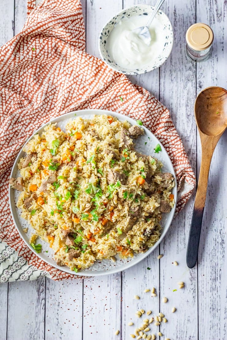 Overhead shot of leftover turkey pilaf on a patterned cloth with a wooden spoon