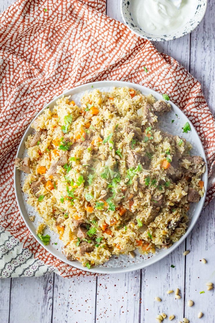 Overhead shot of leftover turkey pilaf on a white wooden background with a patterned cloth