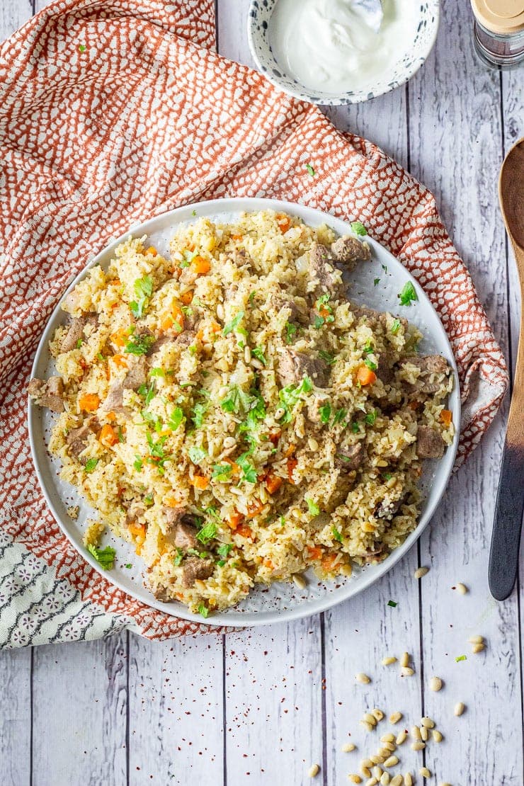 Overhead shot of leftover turkey pilaf on a patterned cloth with a wooden spoon