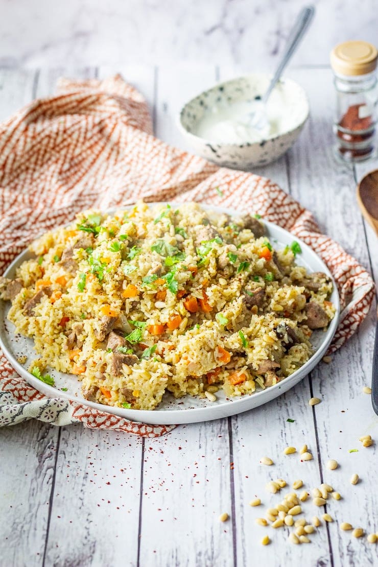 Plate of leftover turkey pilaf on a white wooden background