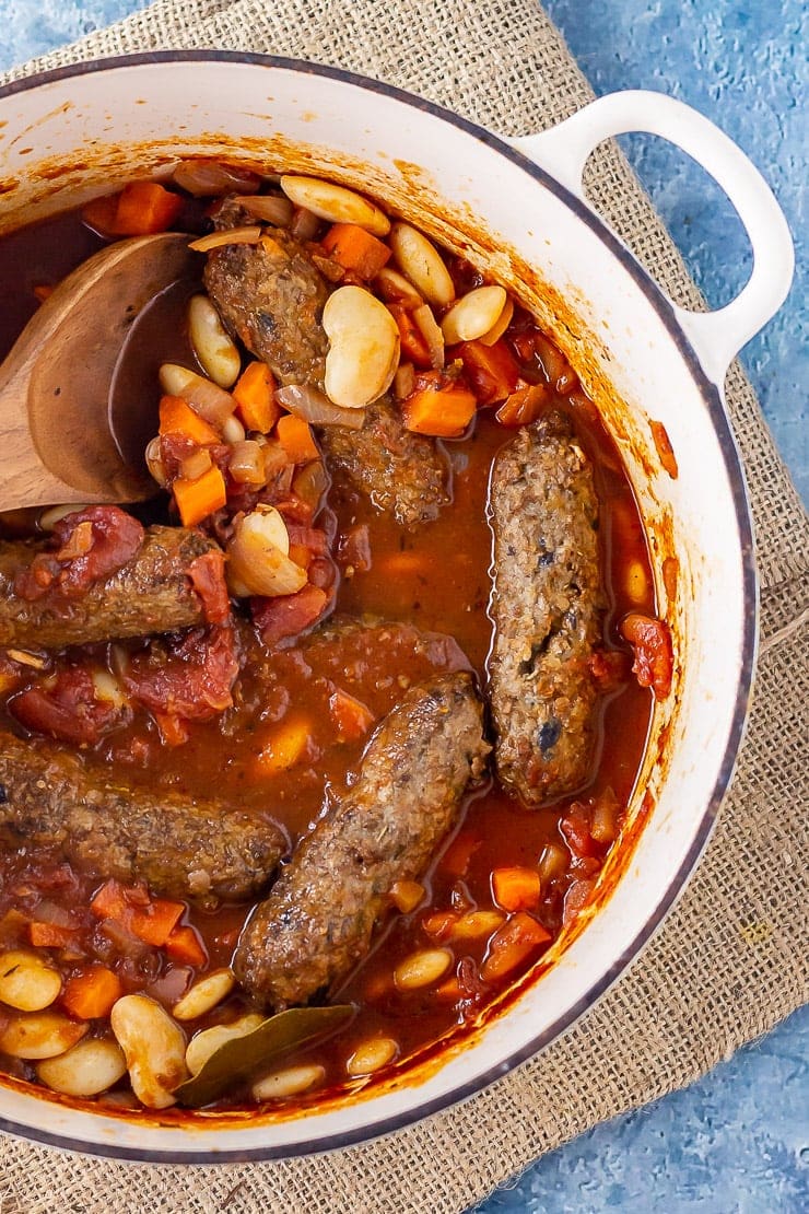 Overhead shot of vegetarian sausage casserole on a mat over a blue background