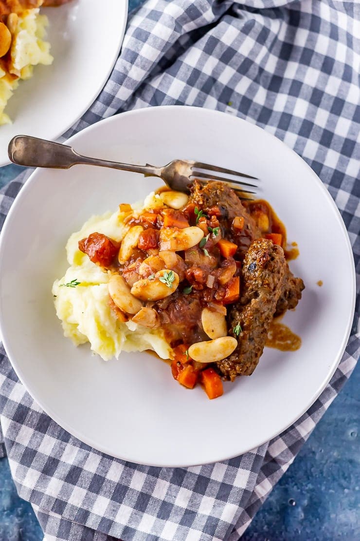 Overhead shot of vegetarian sausage casserole on a checked cloth