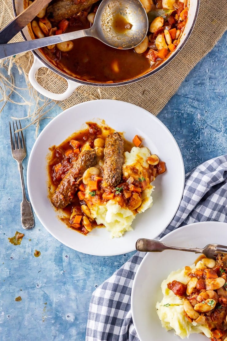 Overhead shot of vegetarian sausage casserole with mash in a white bowl