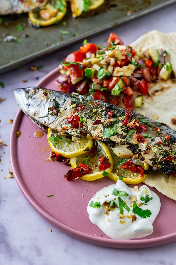 Baked mackerel on a pink plate on a marble background