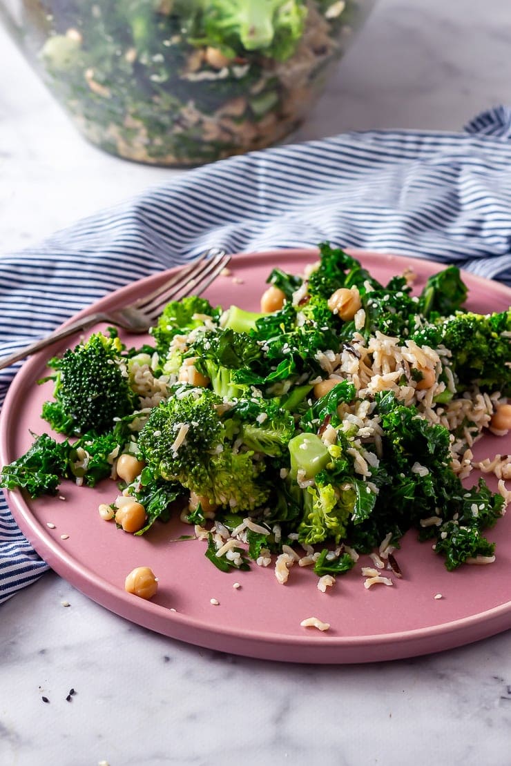Side on shot of broccoli and wild rice salad on a pink plate on a marble background