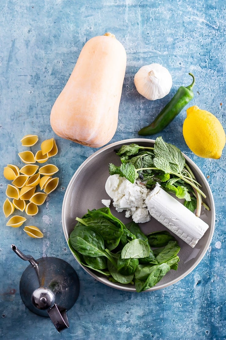 Overhead shot of the ingredients for butternut squash pasta on a blue background