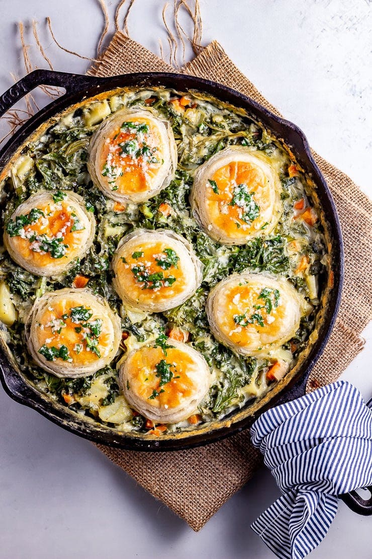 Overhead shot of skillet vegetable pie on a mat with a striped cloth