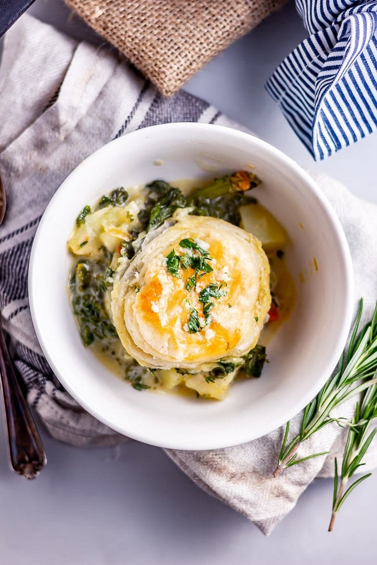 Overhead shot of skillet vegetable pie in a bowl on a cloth with rosemary