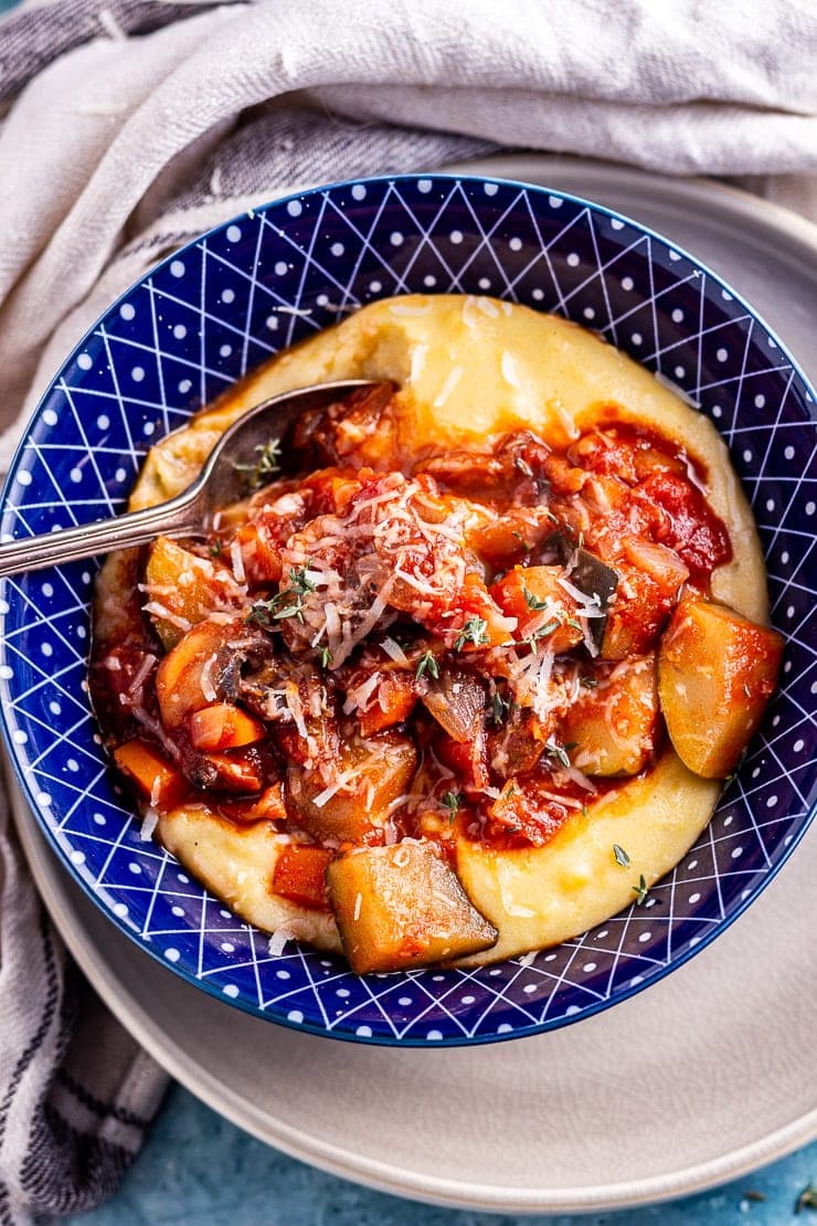 Overhead shot of vegetable stew with creamy polenta in a blue bowl