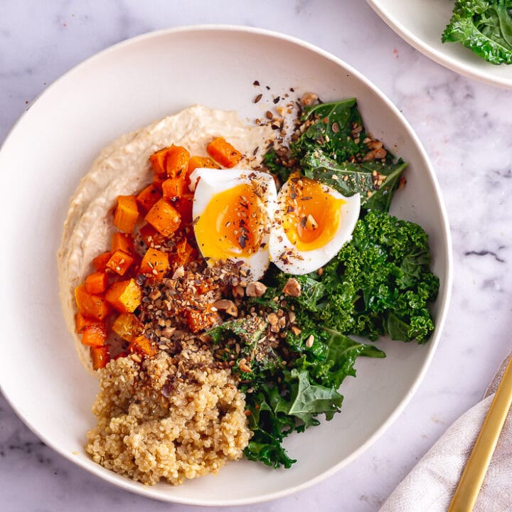 Overhead shot of breakfast bowl with a gold fork on a marble background