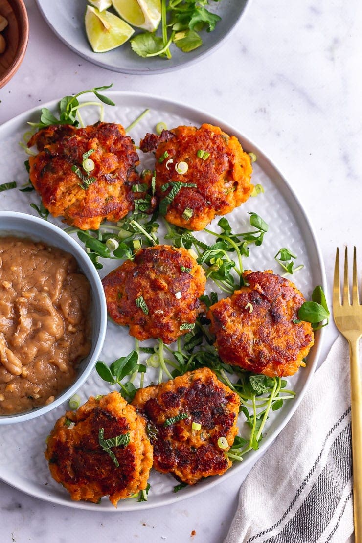 Overhead shot of Thai fish cakes on a platter with peanut sauce