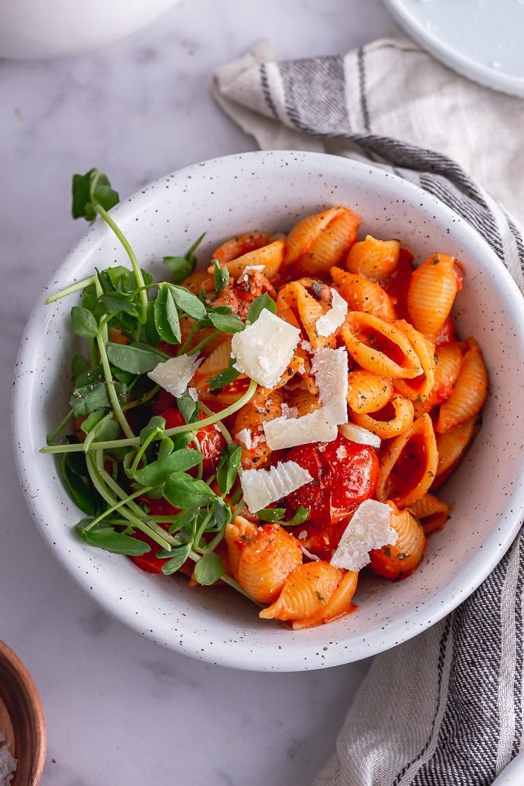 Overhead shot of tomato pasta with greens and parmesan