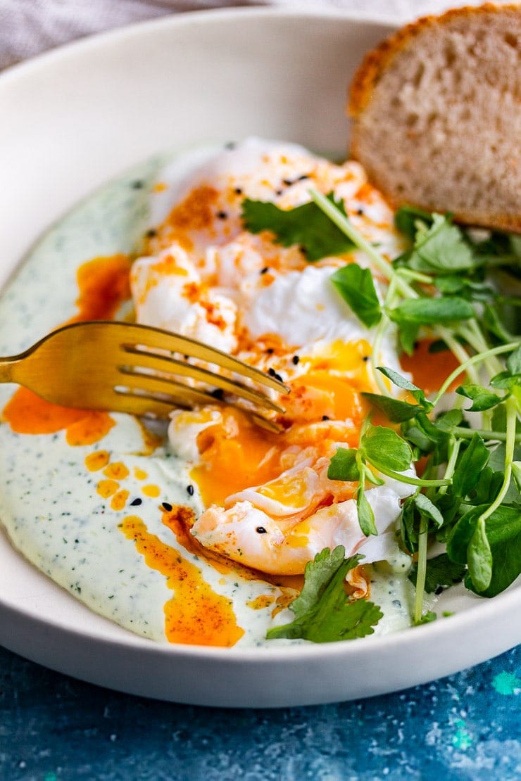 Turkish eggs with a fork breaking the yolk