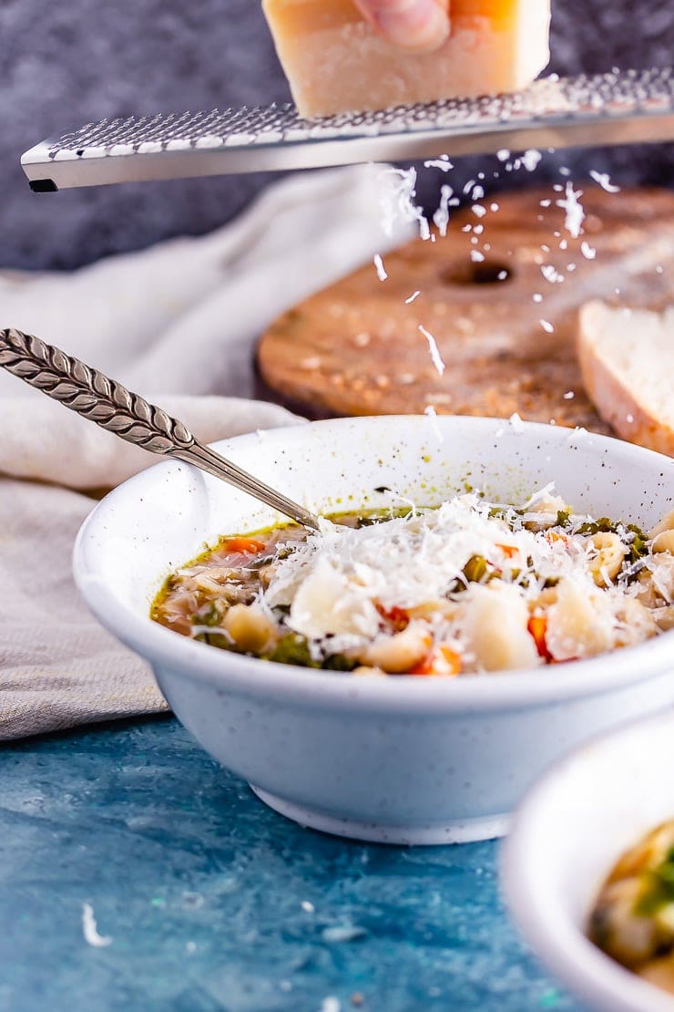 Veggie pesto pasta soup with parmesan grating over the top