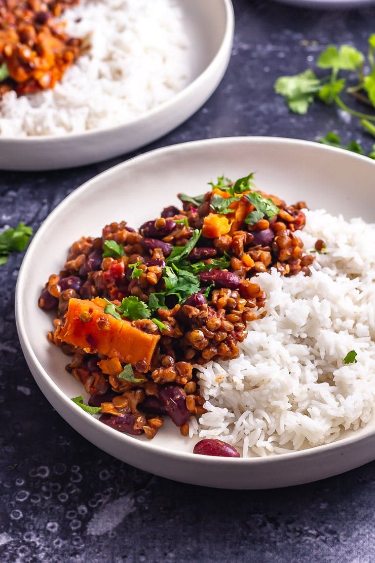 Side on shot of veggie chilli in a white bowl on a dark grey background