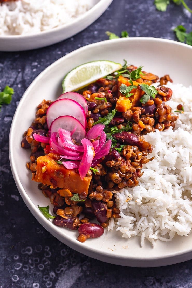 Close up of veggie chilli with toppings and rice in a white bowl