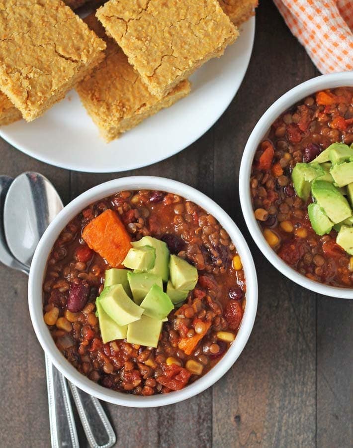 Overhead shot of lentil sweet potato chilli with cornbread for vegan comfort food round up