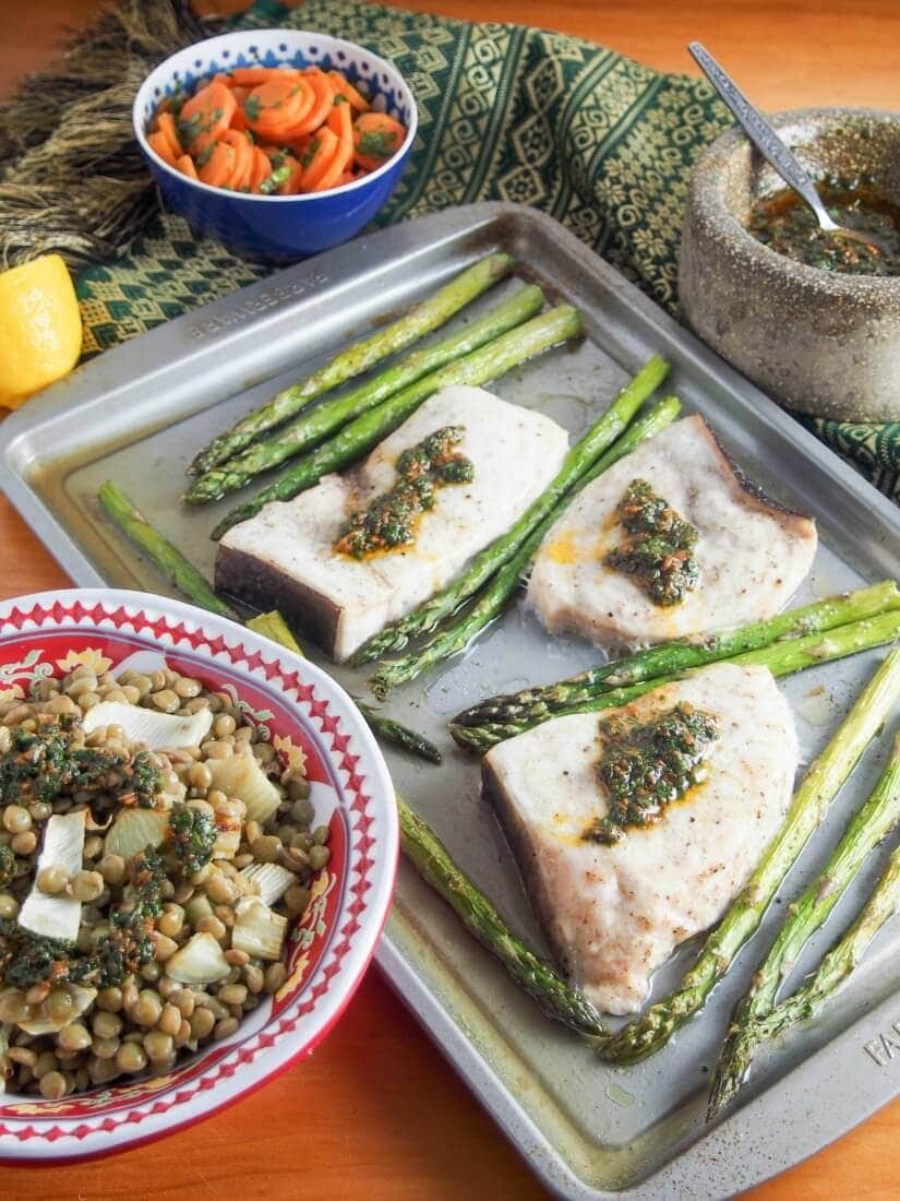 Baked swordfish and asparagus on a baking sheet