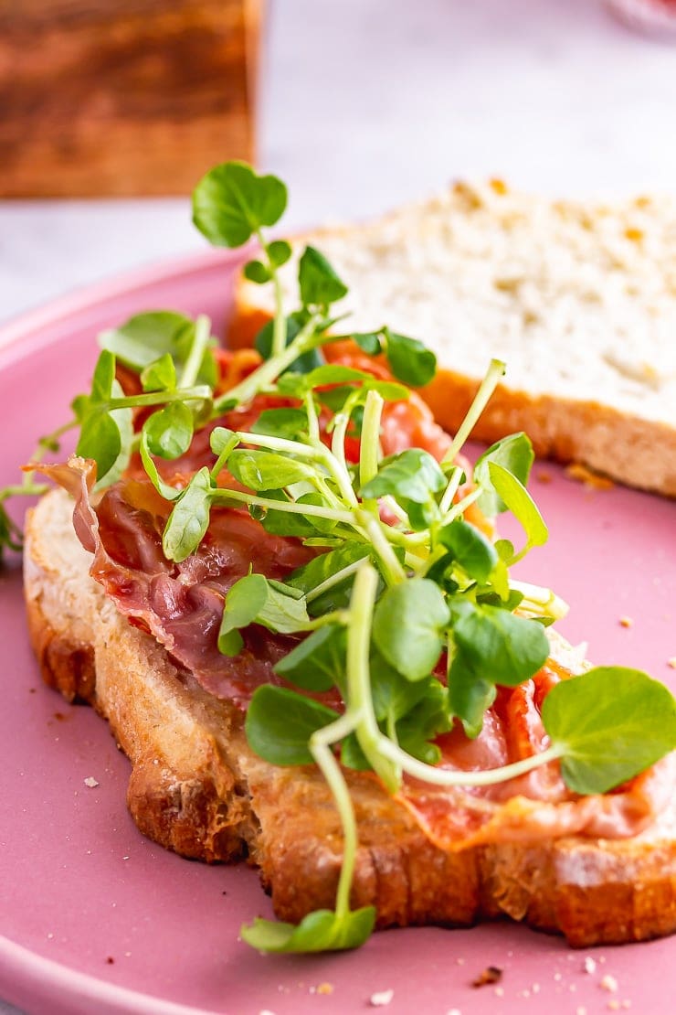 Watercress on a breakfast sandwich on a pink plate