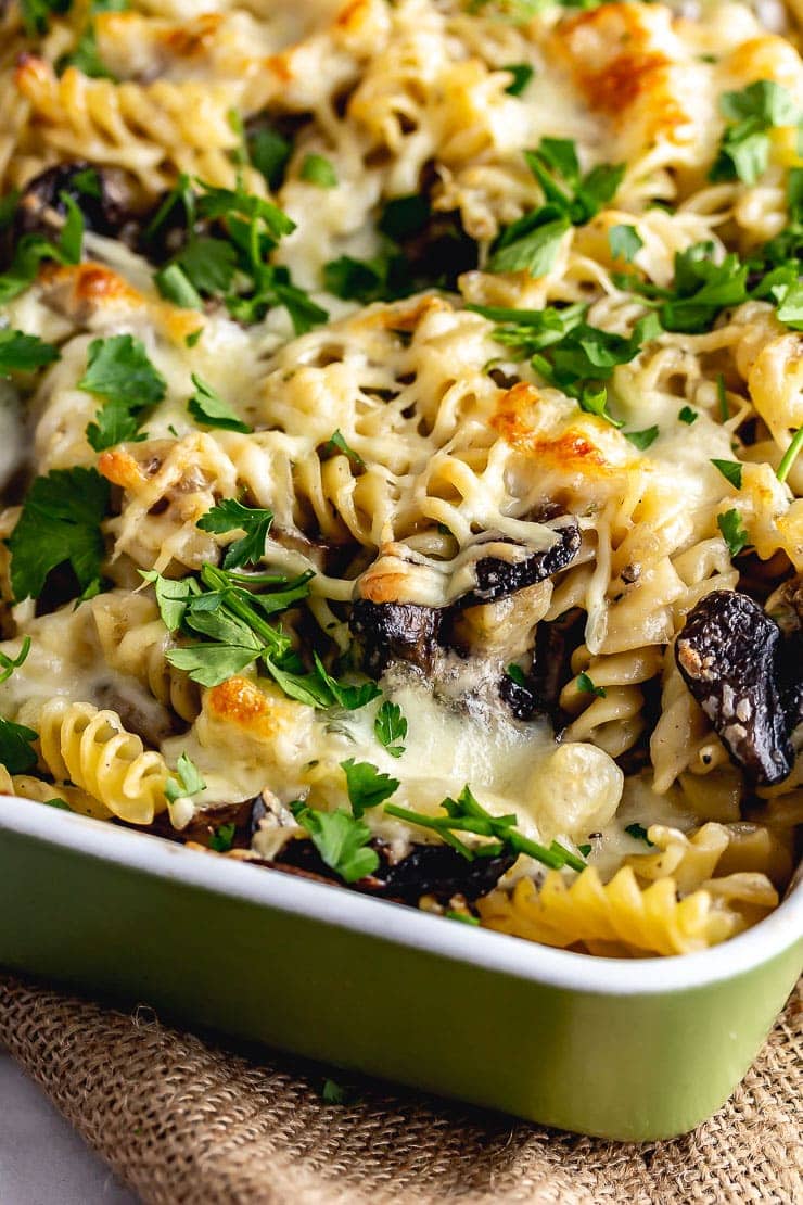 Close up of mushroom pasta bake in a green baking dish