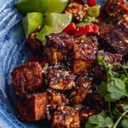 Overhead shot of salt and pepper tofu in a blue bowl with toppings