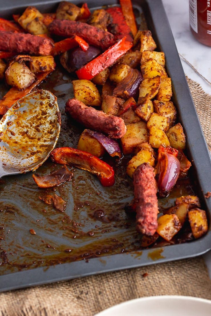 Baking sheet of veggie sausage bake with a spoon