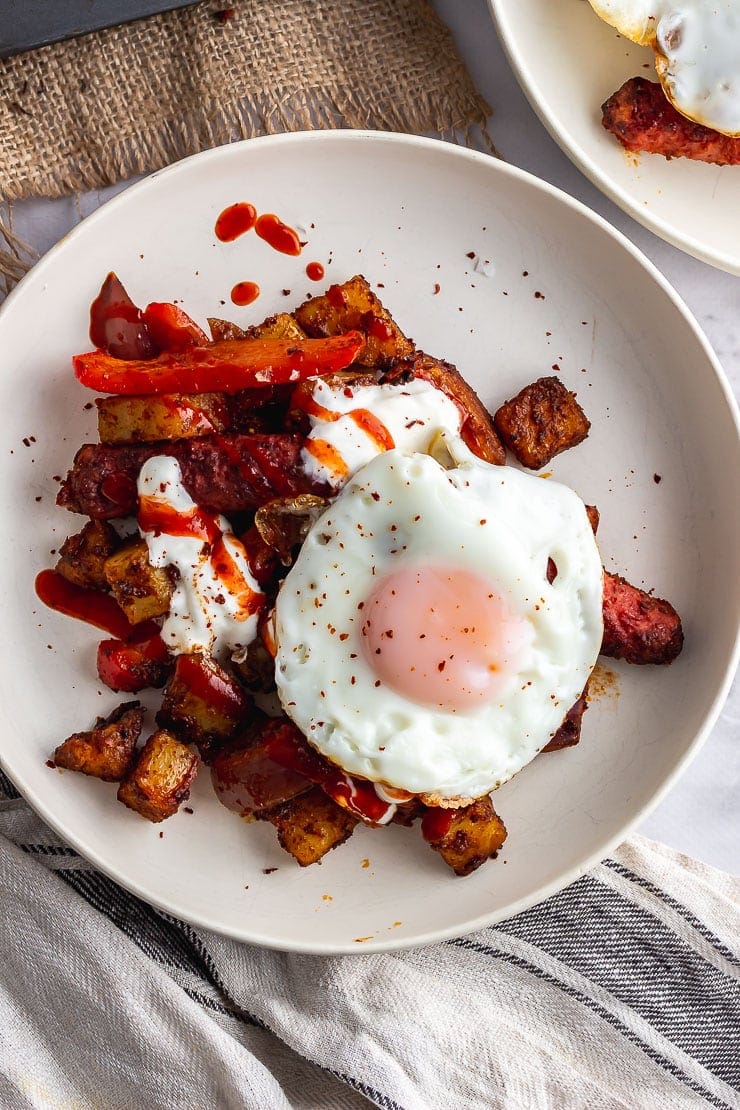 Bowl of sausage tray bake topped with a fried egg 