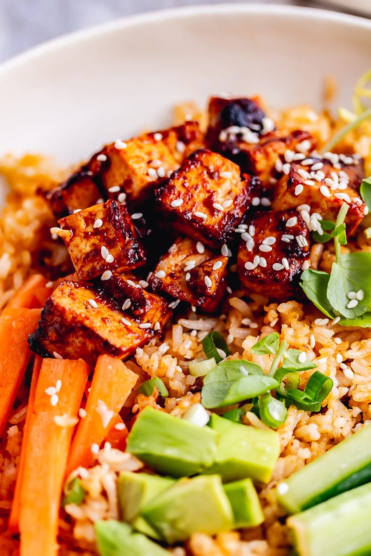 Close up of tofu and vegetables in a spicy rice bowl