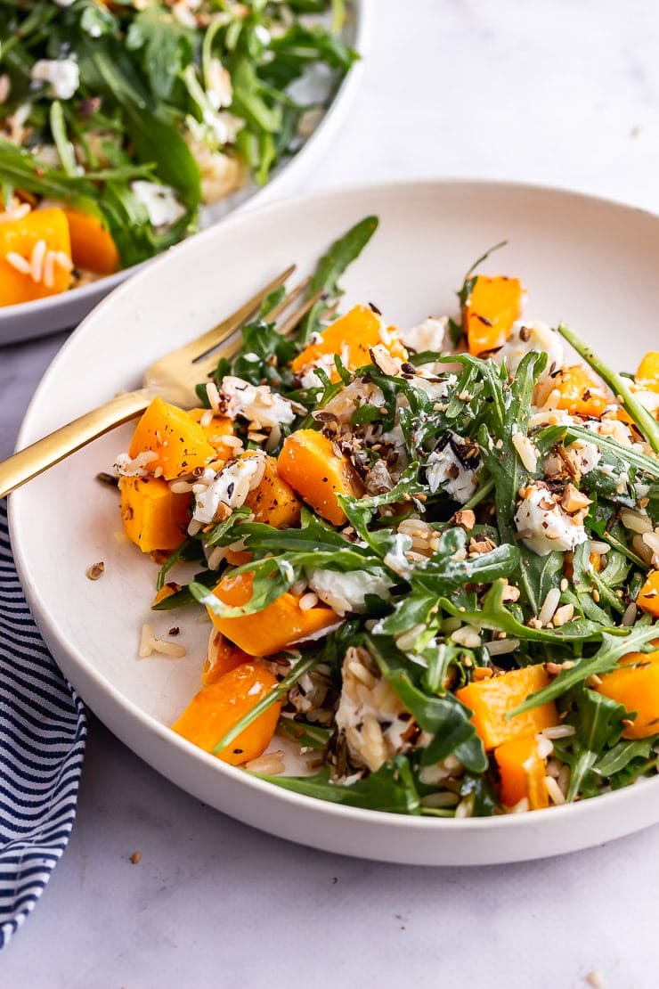 Bowl of butternut squash salad with a gold fork