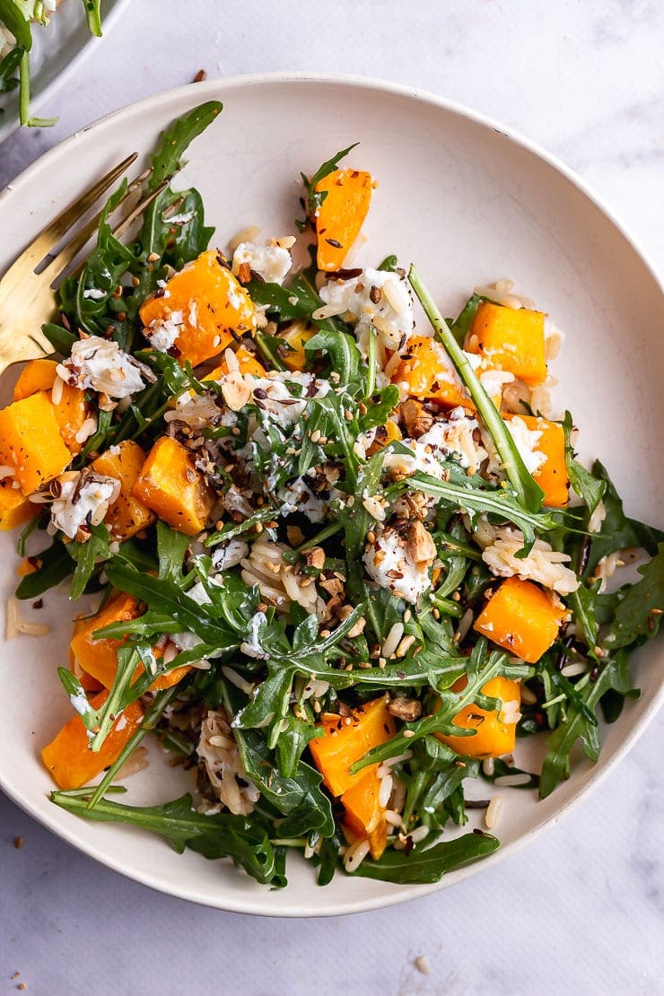 Overhead shot of butternut squash salad with a gold fork