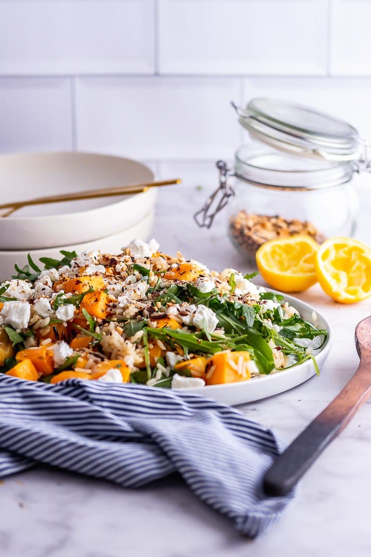 Side on shot of butternut squash salad with a wooden spoon