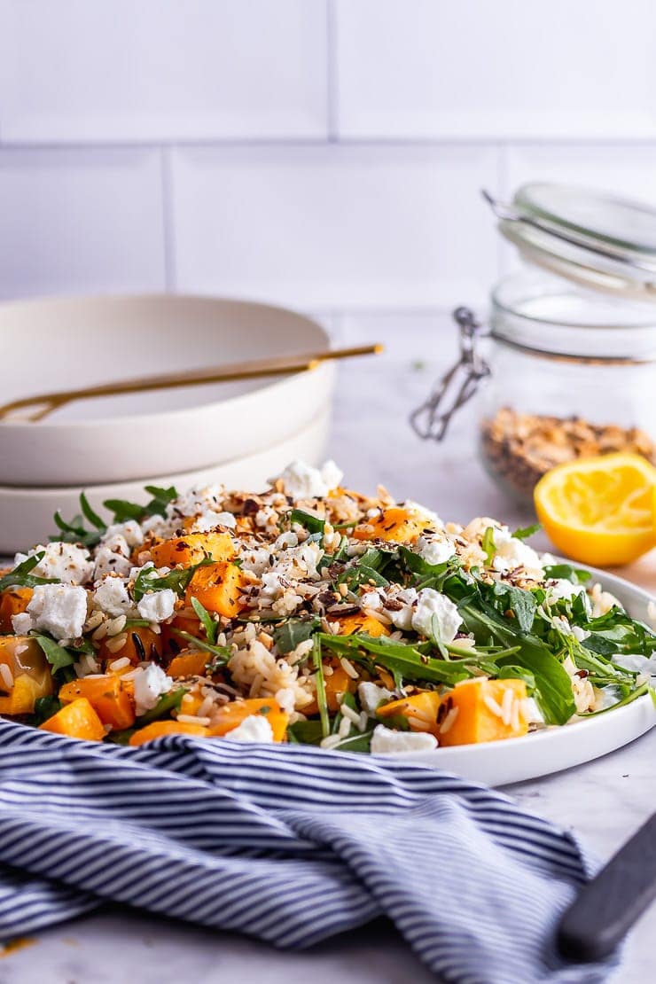 Side on shot of butternut squash salad with lemon and dukkah in the background