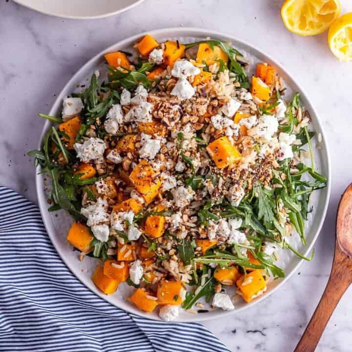 Overhead shot of butternut squash salad on a marble background