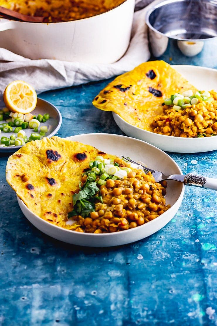 Bowls of chickpea curry with a fork and roti