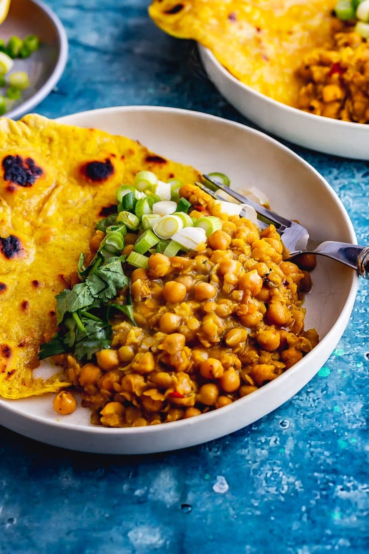 Chickpea curry in a white bowl with roti