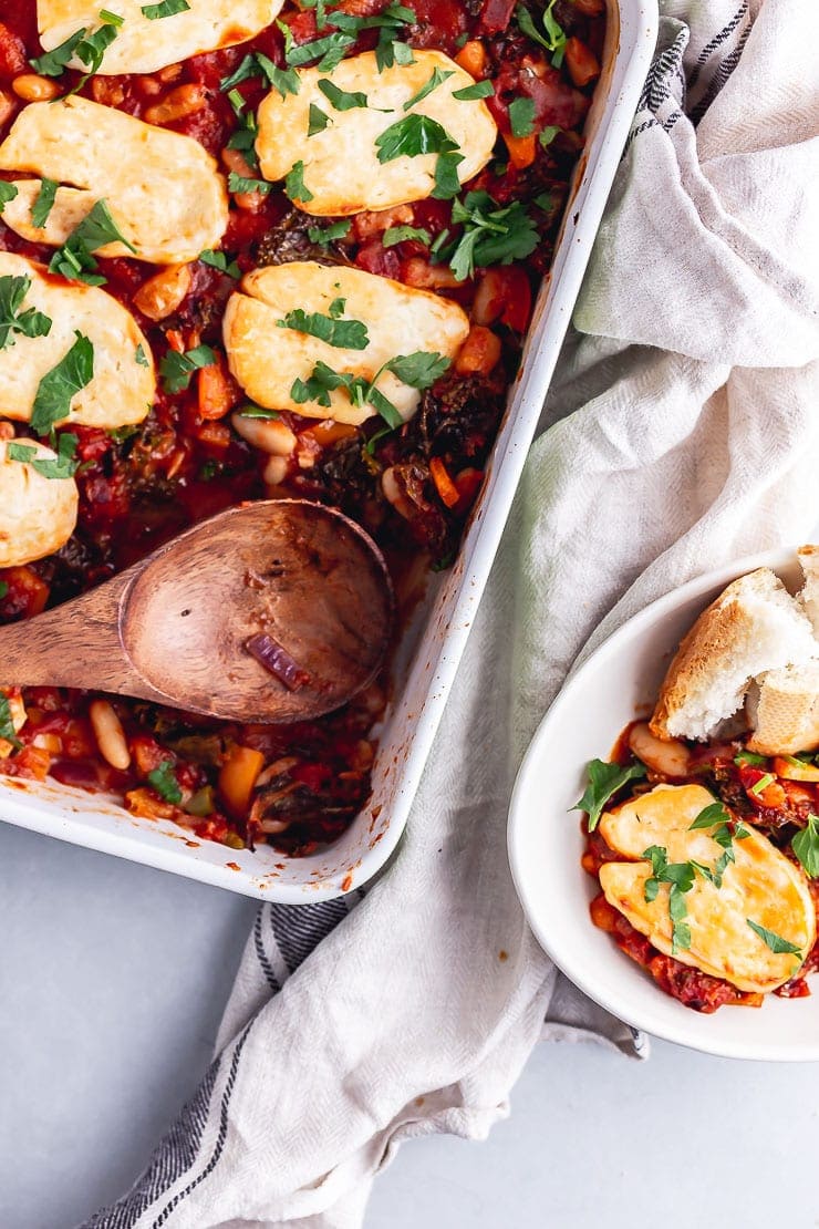 Overhead shot of wooden spoon taking a scoop of halloumi bake