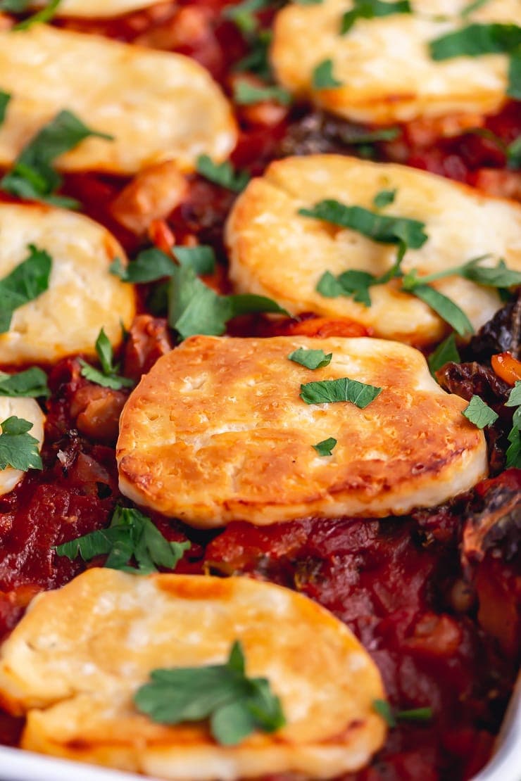 Close up of halloumi and white bean bake topped with herbs