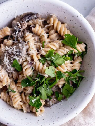 Close up of pressure cooker creamy mushroom pasta in a white speckled bowl